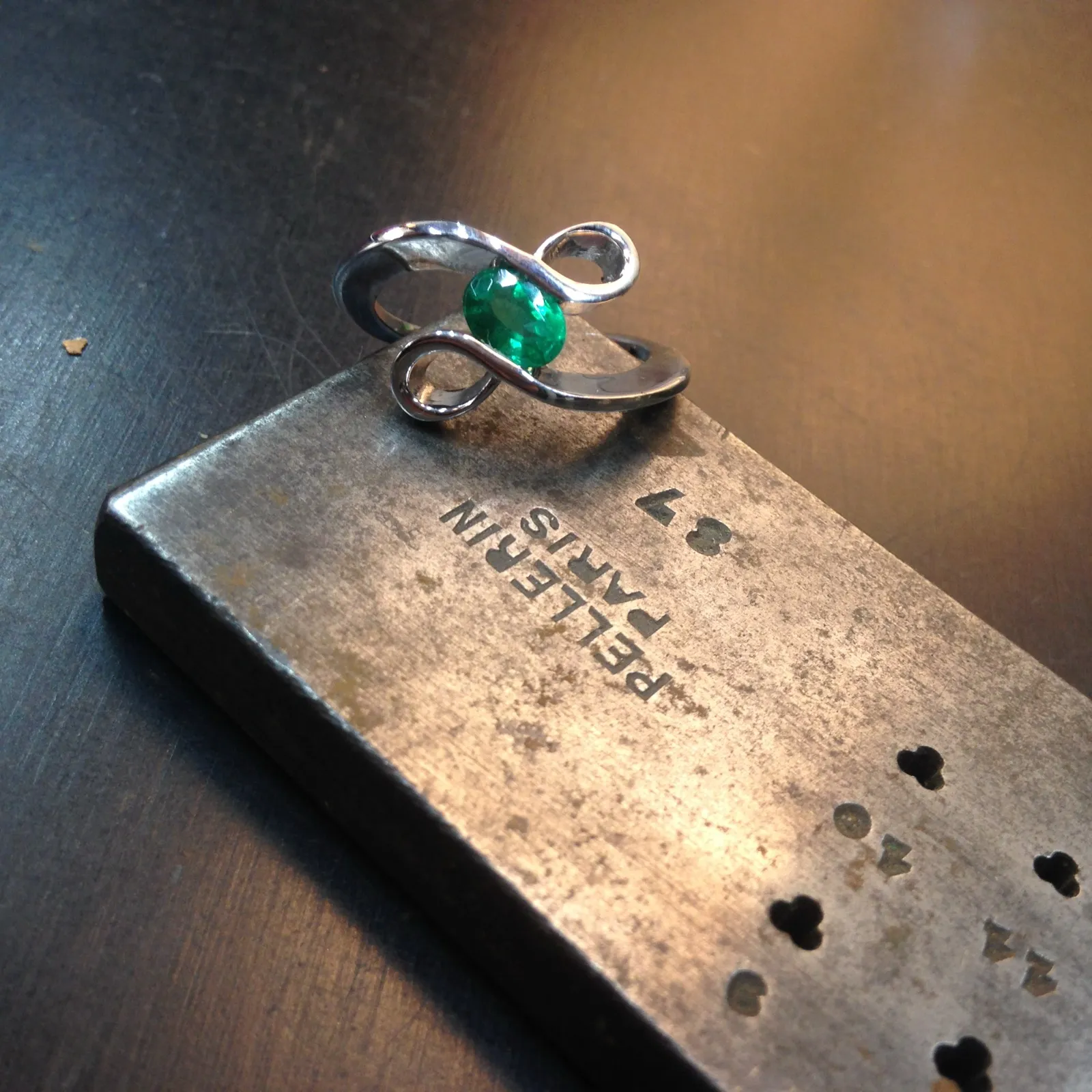 Une bague à émeraude créée par Christophe Berrod, posée sur l'établi